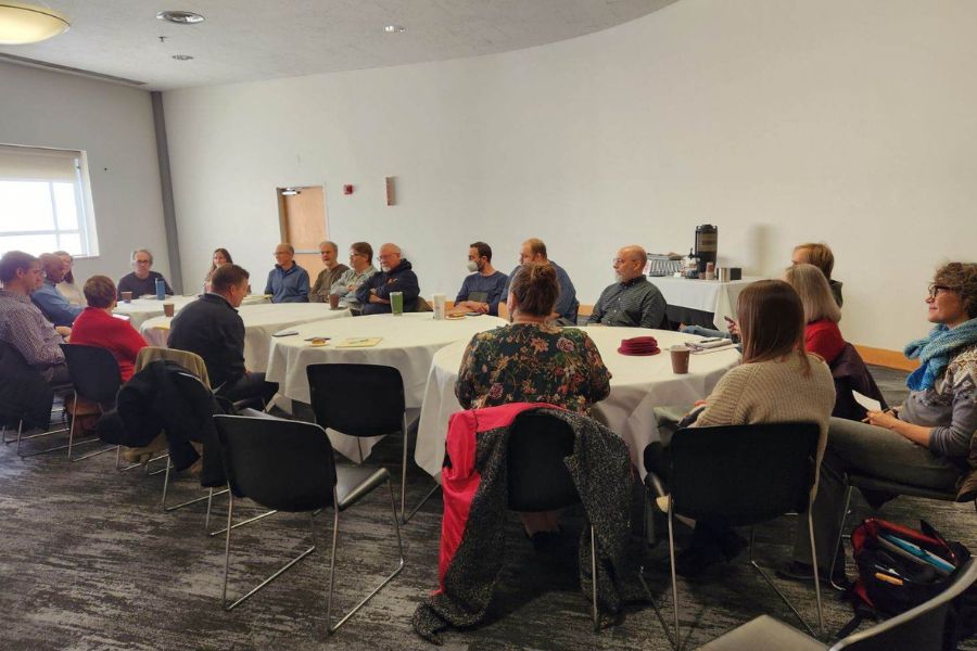 A group of faculty members meet at a conference table in discussion